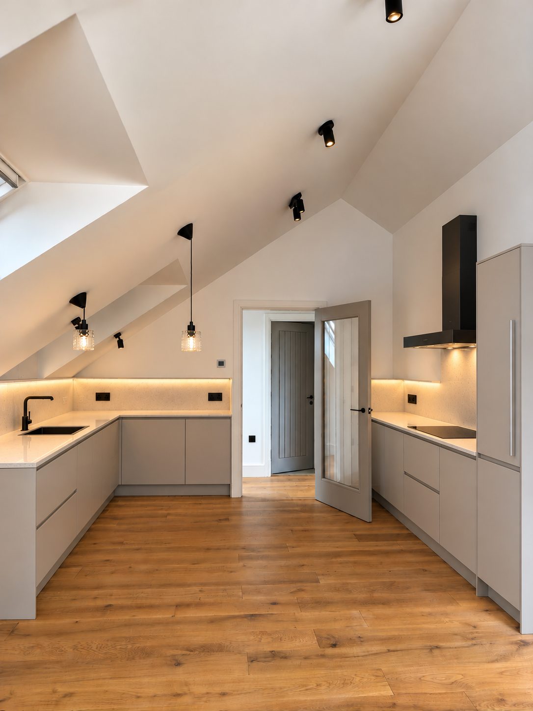 Kitchen set under the pitched roof, with soft under-cabinet light.